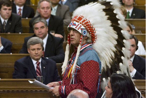 Phil Fontaine, hoofd van de Assembly of First Nations, spreekt het Canadese Lagerhuis toe naar aanleiding van de verontschuldiging voor het beleid van kostscholen voor inheemse kinderen. Premier Stephen Harper (links) kijkt toe. Foto Canadian Press