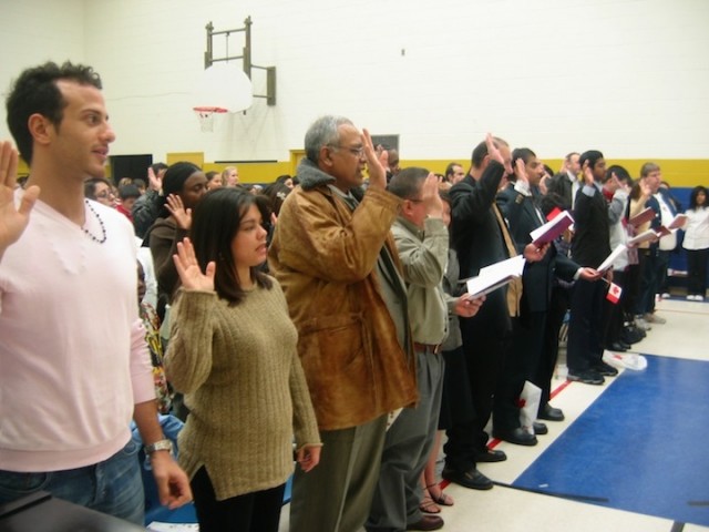 Deelnemers aan een naturalisatieceremonie in het Canadese Hamilton leggen de eed af.