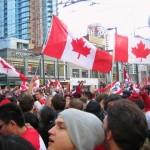 Een menigte Canadezen viert in het centrum van Vancouver het ijshockeygoud voor Canada, de kroon op de Olympische Winterspelen.