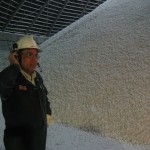 Een werknemer van Potash Corp bij een berg potash of kali, een ingredient van kunstmest.