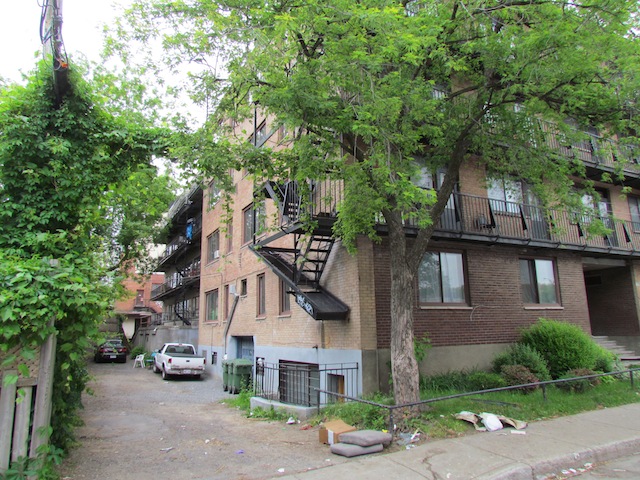The back of the apartment building where Magnotta lived. The building, in the background, shares its  spot for garbage with the neighbouring building in the foreground.