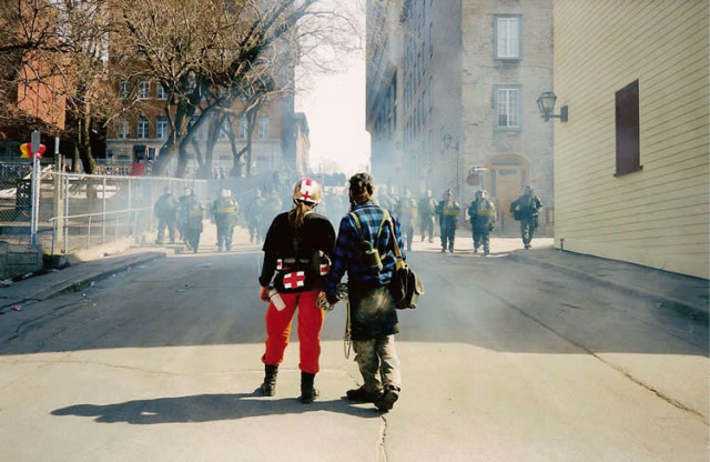 Twee actievoerders staan oog in oog met de mobiele eenheid in Québec-Stad.