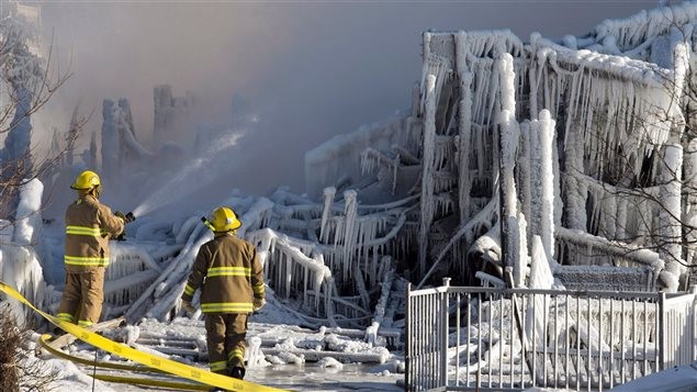 Brandweerlieden bij het bejaardenhuis in l'Isle-Verte dat is verwoest. Foto CP