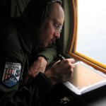 IJswaarnemer Lee Brittle van de Internationale IJspatrouille zoekt naar ijsbergen boven de Atlantische Oceaan.